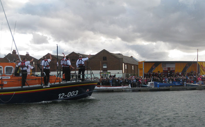 Crew wave to the crowd on the quayside after a breezy annual lifeboat service