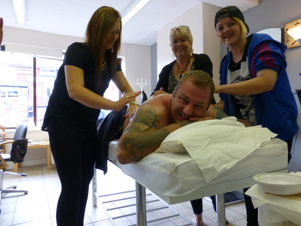 Ian getting waxed by (L-R) Rachael Williamson, Caroline Olive and Rachael Olive