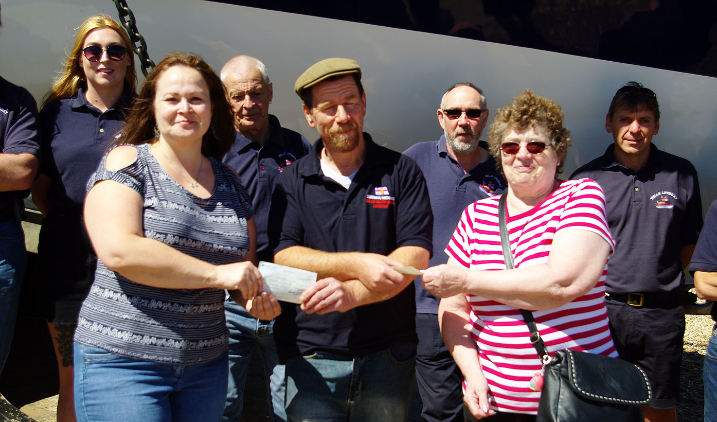 Angie (l) and Jenny (r) present cheques to Coxswain Nicky King