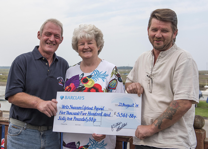 Coxswain Allen Frary receives the cheque from Jill and Kieron