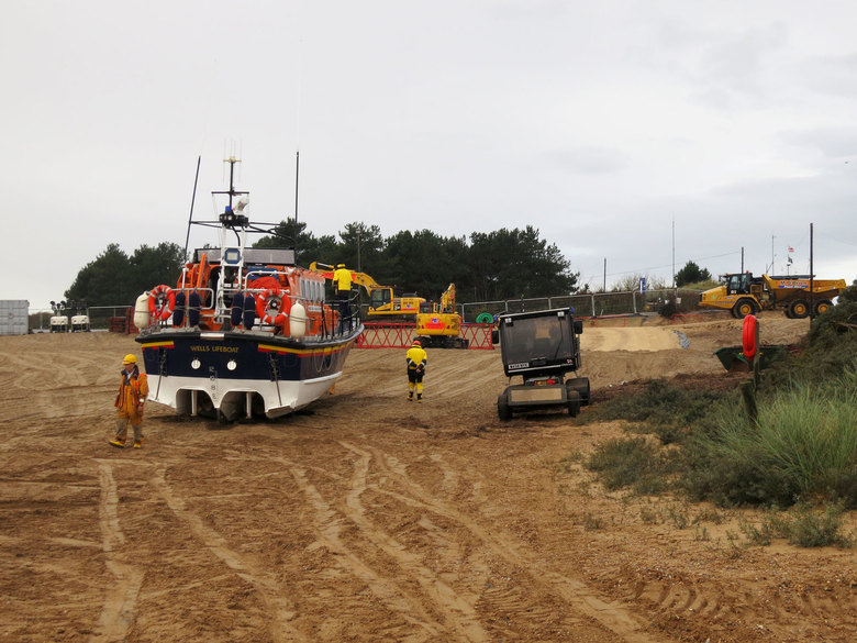 Normal service must go on: the lifeboat is recovered after an exercise on the beach to the east of the building site