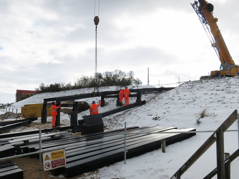 Steelwork being fitted inbetween snow showers