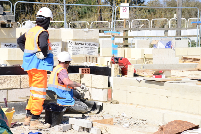 Installing damp proof course and first rows of blockwork around the building