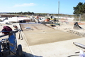 Installing more sections of the concrete apron in front of the building