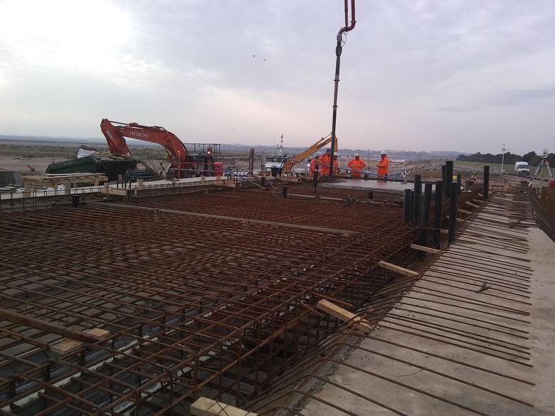 Pouring the first part of the the huge concrete slab on which the building will sit in the future area of the crew facilities and changing room