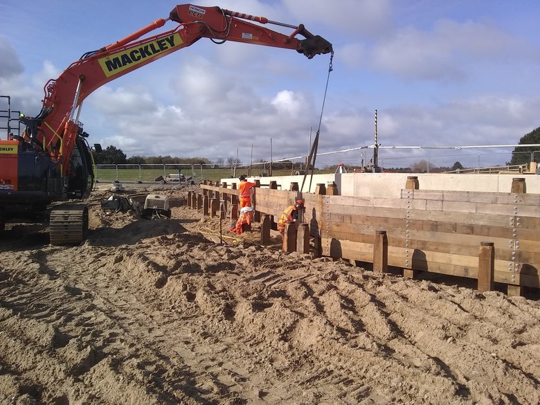 Adding planks to the timber piles around the perimeter of the site