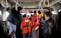 Crew members gather round for an explanation of the joystick helm controls