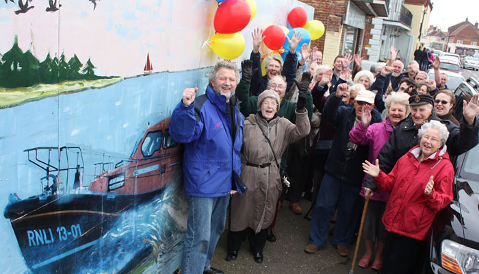 Chairman Peter Rainsford (l) celebrates with Wells Guild members, Swaffham Guild members, Lifeboat crew and supporters