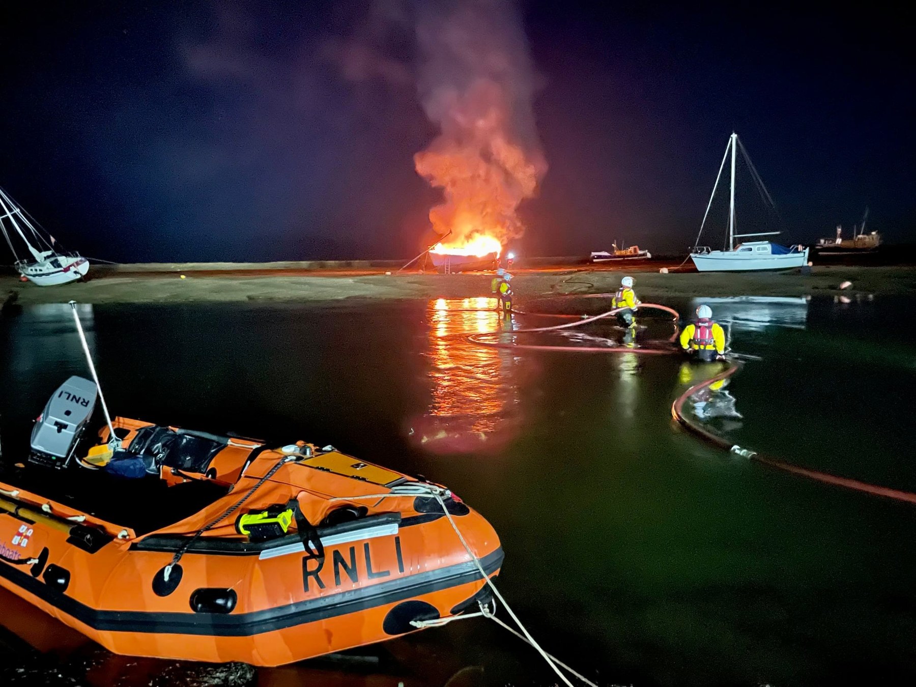 ILB crew assist with feeding fire service hose across the channel, 15/10/21